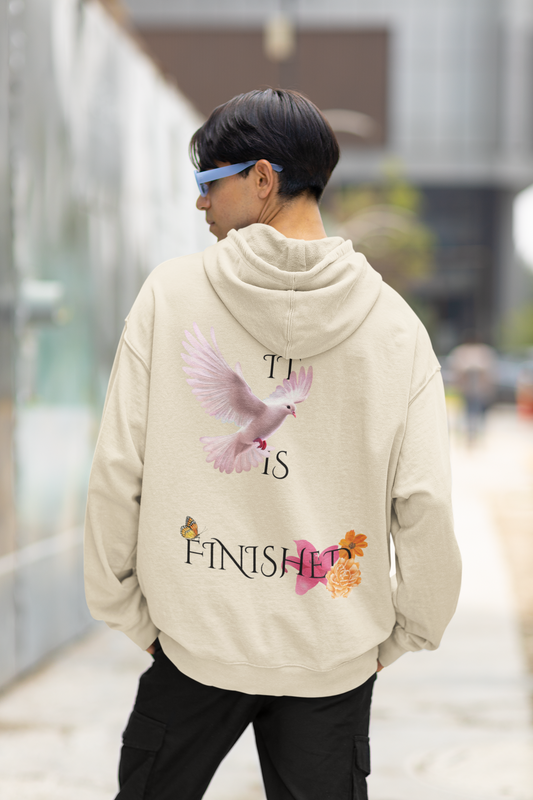 Person wearing a beige hoodie with a graphic design on the back, walking outdoors.