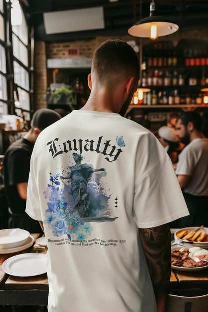 Person wearing a white t-shirt with 'Loyalty' design in a restaurant setting